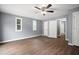 A spacious bedroom with wood floors, ceiling fan, and natural light from multiple windows at 37732 Cecil Ln, Zephyrhills, FL 33542