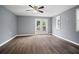 A bright bedroom featuring wood floors, a ceiling fan, and access to a private outdoor deck at 37732 Cecil Ln, Zephyrhills, FL 33542