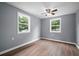 Light-filled bedroom with hardwood flooring, neutral paint, and two sunny windows at 37732 Cecil Ln, Zephyrhills, FL 33542