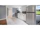 An updated kitchen with white cabinets, stainless steel appliances, and an adjacent bathroom at 37732 Cecil Ln, Zephyrhills, FL 33542