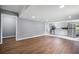 An open-concept living room with wood floors and an adjacent kitchen featuring modern appliances at 37732 Cecil Ln, Zephyrhills, FL 33542