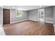 A spacious living room with wood floors and natural light from large windows and a door at 37732 Cecil Ln, Zephyrhills, FL 33542