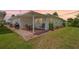 Rear exterior view showcasing a patio, well-maintained lawn, and manicured landscaping at 4076 Mainlands N Blvd, Pinellas Park, FL 33782