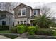 Inviting two-story home with lush landscaping, manicured shrubbery, and a beautiful brown and beige color palette at 4146 Bexley Village Dr, Land O Lakes, FL 34638