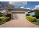 Two-car garage with brick driveway and manicured landscaping at 4146 Bexley Village Dr, Land O Lakes, FL 34638