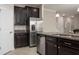 This is a stainless steel kitchen that features dark wood cabinets and granite countertops with a tiled floor at 4146 Bexley Village Dr, Land O Lakes, FL 34638