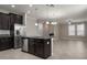 Open-concept kitchen with dark cabinetry, stainless steel appliances, and an island, seamlessly flowing into the living area at 4146 Bexley Village Dr, Land O Lakes, FL 34638