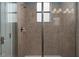 Modern shower with glass enclosure, tiled walls, and a window providing natural light, enhancing the bathroom's design at 4146 Bexley Village Dr, Land O Lakes, FL 34638