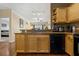Kitchen with granite countertops, wood cabinets, stainless dishwasher, and an open view to the bedroom at 4207 S Dale Mabry Hwy # 8304, Tampa, FL 33611