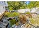 Landscaped backyard featuring a tranquil rock pond with a small waterfall, surrounded by lush greenery and a privacy fence at 428 Klosterman W Rd, Palm Harbor, FL 34683