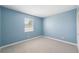 Neutral bedroom has light blue walls, neutral carpet, and a large window at 428 Klosterman W Rd, Palm Harbor, FL 34683