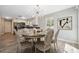 Dining room with modern light fixture, six chairs, and an open view of the updated kitchen at 428 Klosterman W Rd, Palm Harbor, FL 34683