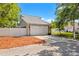 Property featuring a spacious driveway, two-car garage, mature trees, and manicured landscaping at 428 Klosterman W Rd, Palm Harbor, FL 34683