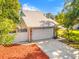 Charming home with a two-car garage, stone accents, well-manicured yard, and a long driveway at 428 Klosterman W Rd, Palm Harbor, FL 34683