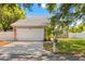Home featuring a white garage door, stone accents, manicured lawn, and mature landscaping at 428 Klosterman W Rd, Palm Harbor, FL 34683