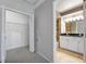 Hallway view into a full bathroom showcasing a double sink vanity and white cabinets at 428 Klosterman W Rd, Palm Harbor, FL 34683