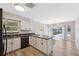 Bright kitchen with white cabinetry, dark countertops, stainless steel appliances, and an island at 428 Klosterman W Rd, Palm Harbor, FL 34683