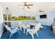 Screened lanai with cozy seating, ceiling fans, and a TV, creating a relaxing outdoor entertainment space at 428 Klosterman W Rd, Palm Harbor, FL 34683