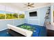 Inviting screened lanai with a ceiling fan, TV, and comfortable seating, perfect for relaxation and entertainment at 428 Klosterman W Rd, Palm Harbor, FL 34683