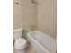 Bright bathroom featuring a tiled shower-tub and toilet at 474 Hinton St, Port Charlotte, FL 33954
