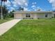 Charming single-story home with a well-manicured lawn, a neutral color palette, and an attached garage at 474 Hinton St, Port Charlotte, FL 33954