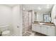 Well-lit bathroom featuring a granite countertop, ample storage, and shower with patterned curtain at 504 S Armenia Ave # 1329B, Tampa, FL 33609