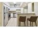 White kitchen featuring stainless steel appliances, breakfast bar, granite countertops, and tile flooring at 504 S Armenia Ave # 1329B, Tampa, FL 33609