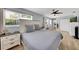 Light-filled bedroom with wood floors, a ceiling fan, and a large window overlooking the greenery outside at 5044 17Th N St, St Petersburg, FL 33714