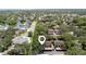 An aerial view of the condo community with trees, landscaping and a lake in the background at 506 Duxbury Ct # A, Safety Harbor, FL 34695