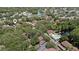 Aerial view showing the community pool and lake among the homes and mature trees at 506 Duxbury Ct # A, Safety Harbor, FL 34695