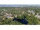 Overhead drone shot of property and the surrounding community including pond and trees at 506 Duxbury Ct # A, Safety Harbor, FL 34695