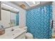 Cozy bathroom featuring a shower with stylish blue tile curtain, sink and mirror at 506 Duxbury Ct # A, Safety Harbor, FL 34695