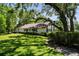 An exterior of the single story home, surrounded by green grass and mature, shady trees at 506 Duxbury Ct # A, Safety Harbor, FL 34695