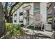 Exterior view of condominium building with staircase and mature landscaping at 506 Duxbury Ct # A, Safety Harbor, FL 34695