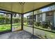Enclosed patio with screen windows overlooking a green backyard and the neighbor's two-story home at 506 Duxbury Ct # A, Safety Harbor, FL 34695