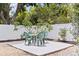 Outdoor dining space features a table with seating surrounded by lush landscaping and a white privacy fence at 5221 4Th N Ave, St Petersburg, FL 33710