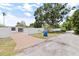Home exterior with paved driveway, grassy lawn, white privacy fence, and mature shade trees at 5221 4Th N Ave, St Petersburg, FL 33710