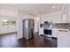Modern kitchen boasts stainless steel appliances, white cabinets, and a view of living room space at 5221 4Th N Ave, St Petersburg, FL 33710