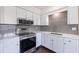 Upgraded kitchen featuring stainless steel appliances, gray backsplash, modern fixtures, and white cabinets at 5221 4Th N Ave, St Petersburg, FL 33710
