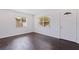 Bright living room features hardwood floors, white walls, and natural light from two windows flanking the front door at 5221 4Th N Ave, St Petersburg, FL 33710