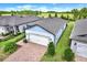 Aerial view of a single Gathering home with a two car garage, brick driveway, and well-maintained landscaping at 6019 Shorebird Br, Land O Lakes, FL 34638