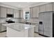 Modern kitchen with stainless steel appliances, grey cabinets, and a kitchen island at 6019 Shorebird Br, Land O Lakes, FL 34638