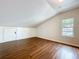 Attic room featuring hardwood floors and a sloped ceiling at 606 N Merrin St, Plant City, FL 33563