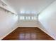 Attic space with hardwood floors, white walls, sloped ceilings, and low window at 606 N Merrin St, Plant City, FL 33563