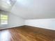 Attic space with hardwood floors, white walls, sloped ceilings and a single window at 606 N Merrin St, Plant City, FL 33563