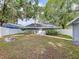 Backyard view of the house with a fire pit, a well-maintained lawn, and a white fence at 606 N Merrin St, Plant City, FL 33563