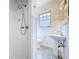 The bathroom features a shower, window, pedestal sink, and tile floors, offering a cozy space at 606 N Merrin St, Plant City, FL 33563