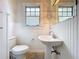 This bathroom has a pedestal sink and wainscoting, offering a functional and charming design at 606 N Merrin St, Plant City, FL 33563