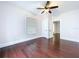 Bedroom with hardwood floors, white trim, and a ceiling fan at 606 N Merrin St, Plant City, FL 33563
