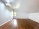 This bedroom features hardwood floors, neutral paint, and a window offering natural light at 606 N Merrin St, Plant City, FL 33563